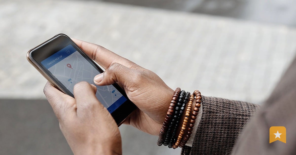 Hand holding a phone displaying a Google Map on a city street, showing how customers find local businesses online.