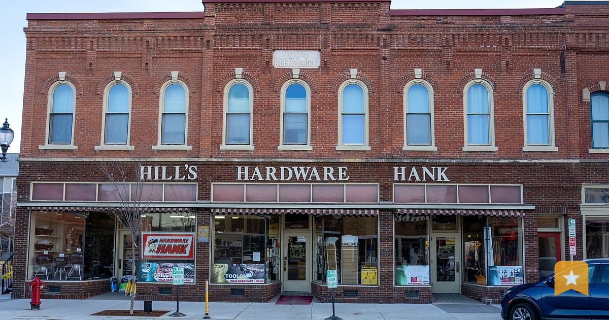 Hill's Hardware storefront on a brick main street, the kind of local shop that needs a claimed Google Business Profile to