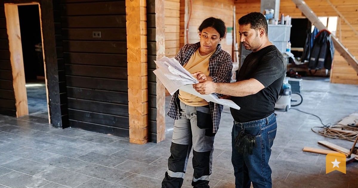 Two contractors review blueprints together on a job site, the kind of work homeowners evaluate through reviews