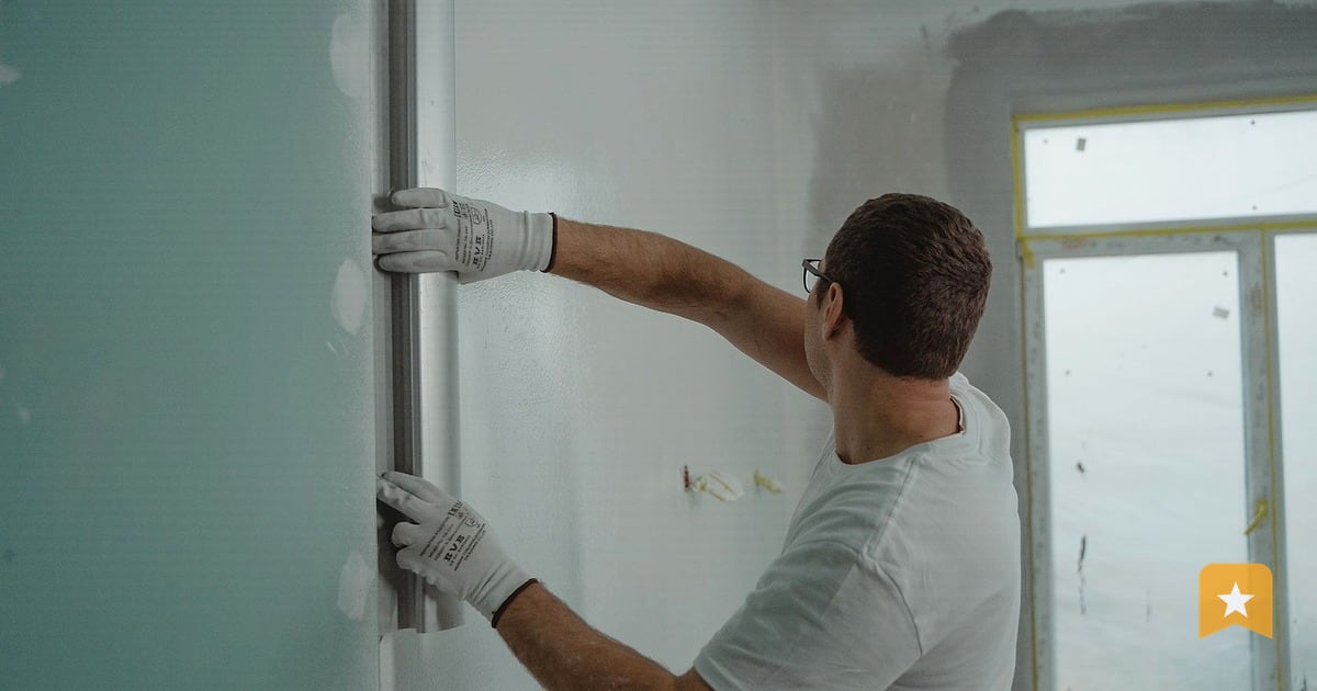 Contractor installing a metal pipe on a drywall interior, the kind of hands-on work that builds a plumber's local reputation.