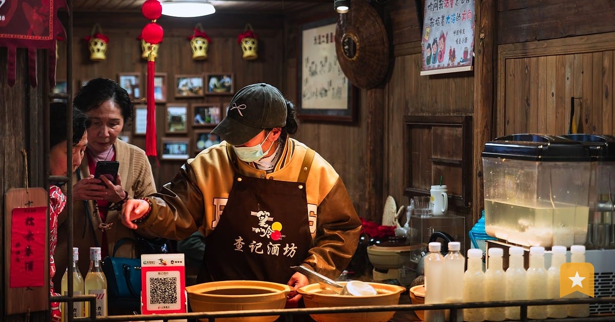Chef in yellow apron and mask preparing food at a wooden counter in a traditional restaurant
